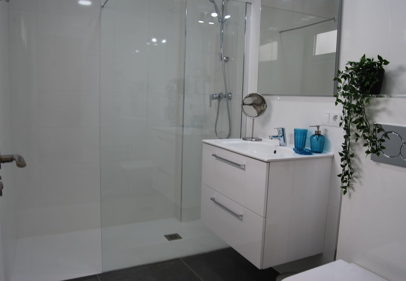 Cuarto de baño moderno y luminoso con ducha.