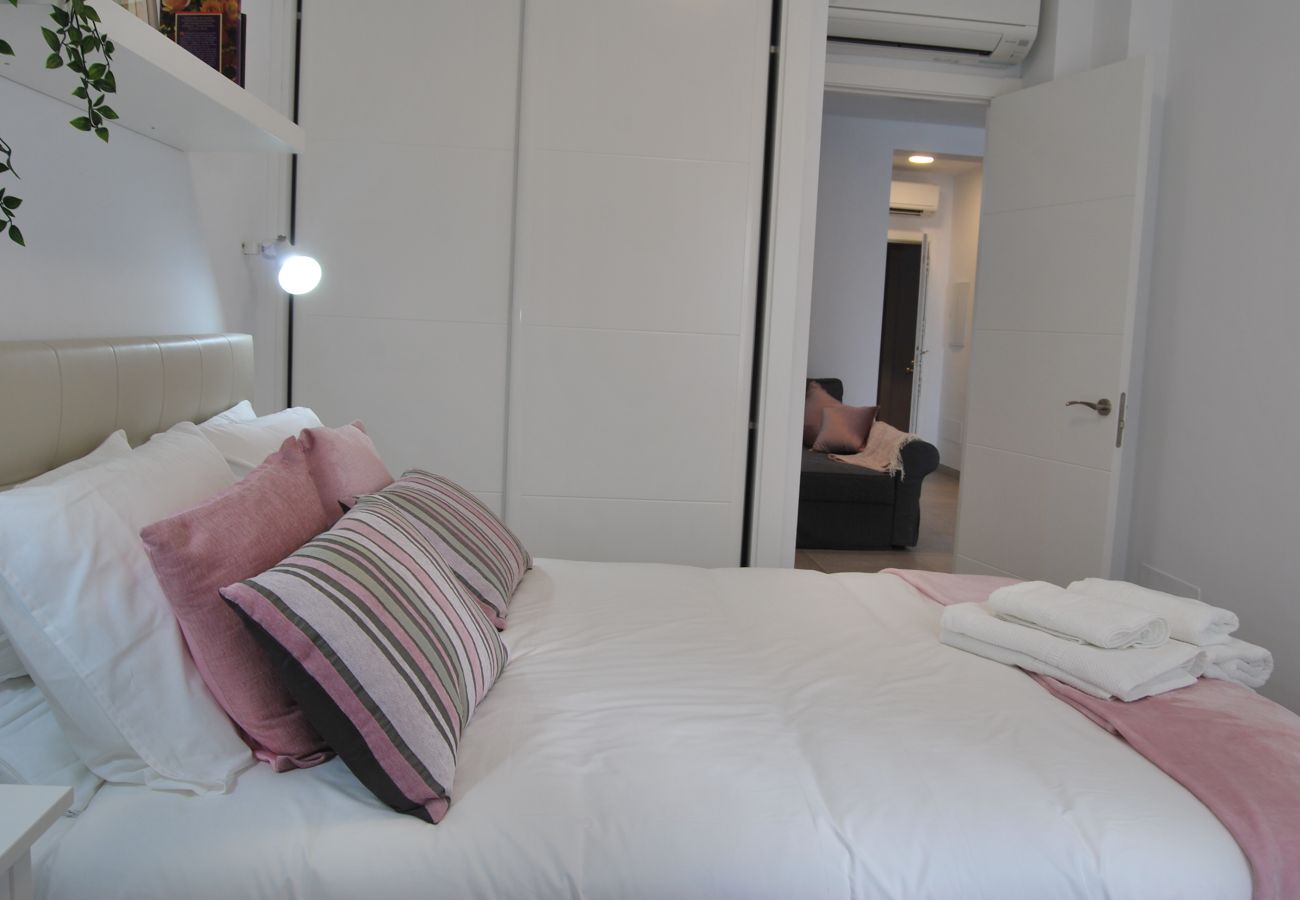 Dormitorio con cama doble con armarios y aire acondicionado.